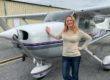 Woman Standing by Small White Plane Near Hanger with Hangarkeepers Insurance